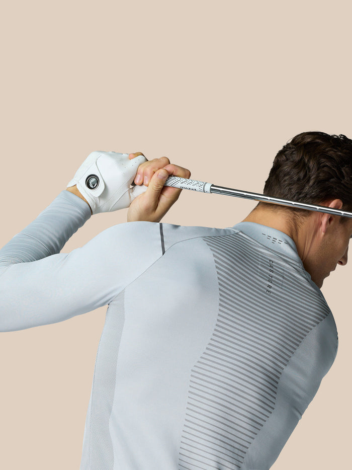 Golfer in mid grey Pinnacle LVS 1/4 Zip Top seen from back gripping a golf club across shoulders