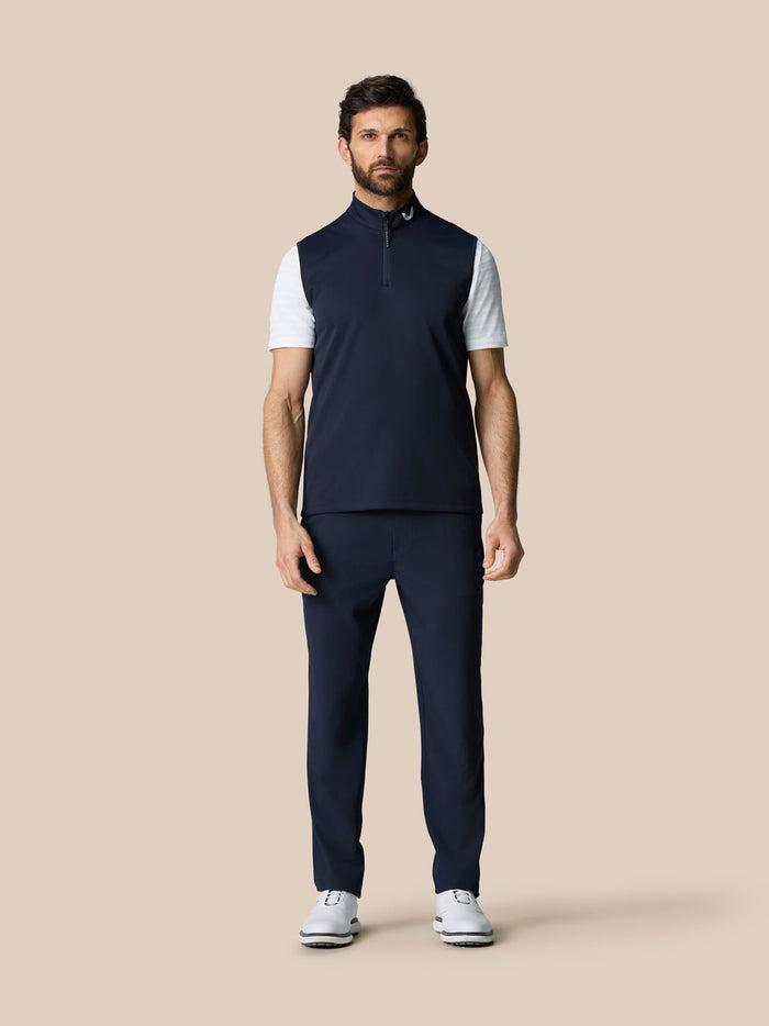 Full body front view of man in navy Club 1/2 Zip Gilet over white tee with matching navy pants and white shoes.