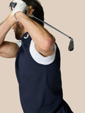 Side view of a man in navy Club 1/2 Zip Gilet swinging a golf club.