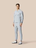 Full body shot of a male model in a light grey LVS woven golf jacket with matching pants and white golf shoes.