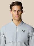 Male model wearing light grey Castore golf pinnacle LVS woven jacket with zip against a neutral background.