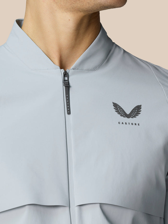 Close-up of light grey jacket chest with a front zipper and CASTORE wing logo.