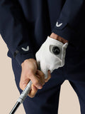 Close-up of navy LVS woven jacket sleeve with Castore wing logo and gripping a golf club