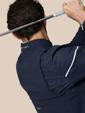 Rear view of golfer wearing midnight navy LVS woven jacket during a swing