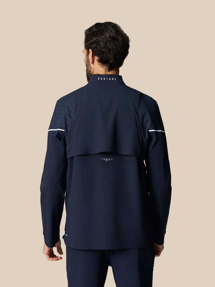 Back view of man in midnight navy LVS woven jacket showing vent panels and logo at collar