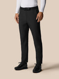 Full-length view of a man wearing black golf winter trousers with a black belt and black shoes.