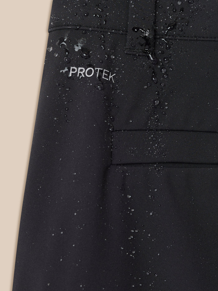 Close-up of black ProTek fabric with water droplets and back pocket stitching on golf trousers