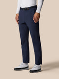 Male model wearing midnight navy golf winterised trousers with woven belt and white sneakers