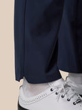 Close-up of navy winter golf trouser leg at the ankle with white sneakers