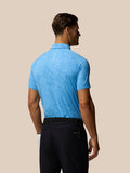 Back view of a man wearing a light blue Glow Printed Polo with subtle pattern and small logo at upper back.