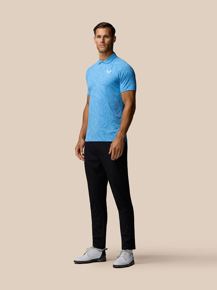 Male model wearing Cool Blue Glow Printed Polo with subtle pattern, three-button collar and Castore logo on left chest.
