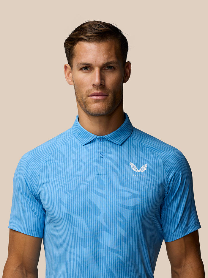 Front view of a man wearing a light blue Glow Printed Polo with a small left chest logo.