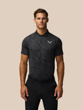 Man wearing gunmetal and mid gray Glow Printed Polo with tonal print three button placket and left chest Castore logo.
