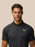 Close up front view of a man wearing a charcoal golf polo with a subtle striped pattern and Castore logo on the left chest