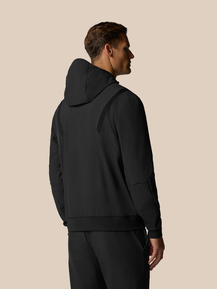 Back view of a man wearing a black Castore Golf Pinnacle Performance Hoodie with a three panel hood.