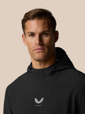 Portrait of a man wearing the black Golf Pinnacle Performance Hoodie with Castore logo centered on the chest