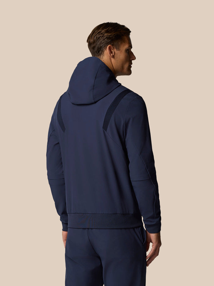 Back view of a man wearing midnight navy golf pinnacle hoodie with three panel hood and elastic shoulder panels.
