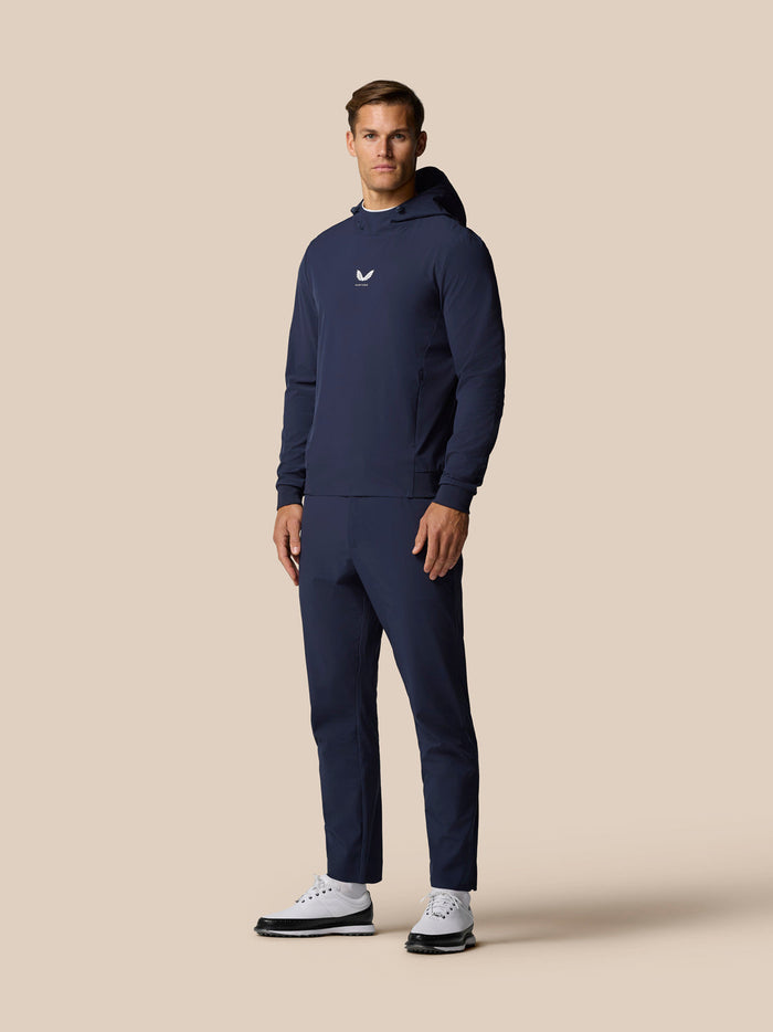 Front view of a man wearing midnight navy golf pinnacle hoodie with hood down and Castore logo on the chest.