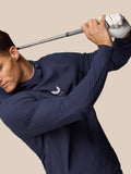 Golfer in midnight navy Castore hoodie preparing a backswing with a golf club.