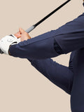 Golfer gripping a club in a navy performance hoodie sleeve during swing