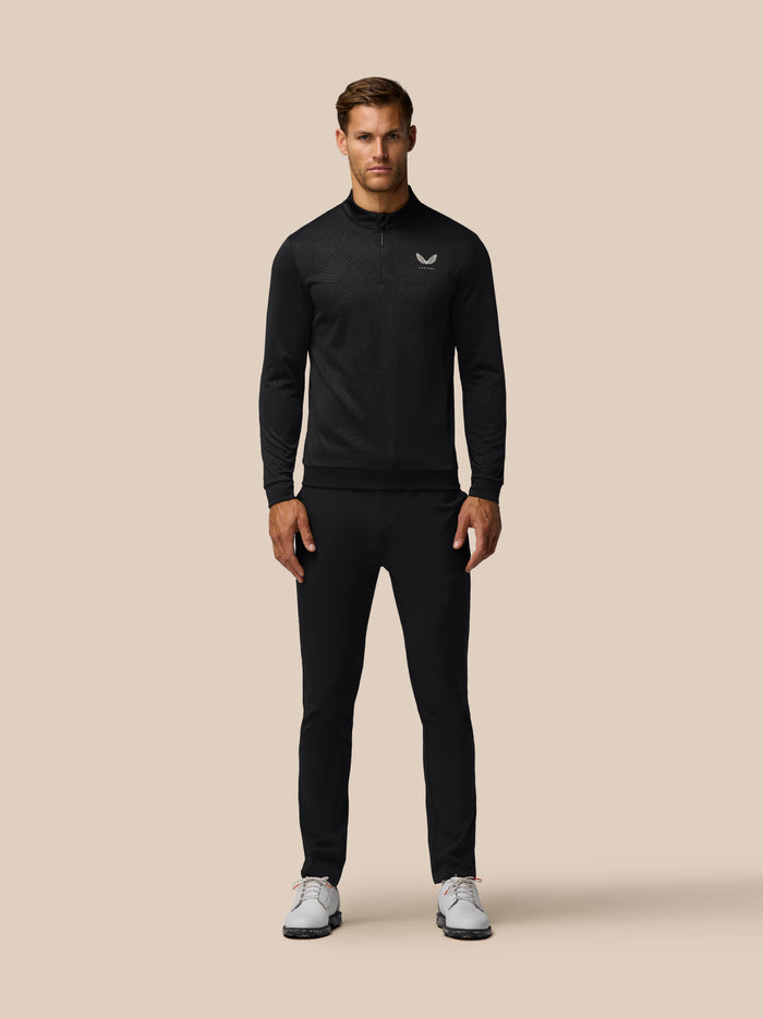 Male model wearing black golf club classic quarter-zip debossed top with all-over print.