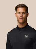Close-up of male golfer wearing black Golf Club Classic quarter-zip top with all-over print and Castore logo on left chest.
