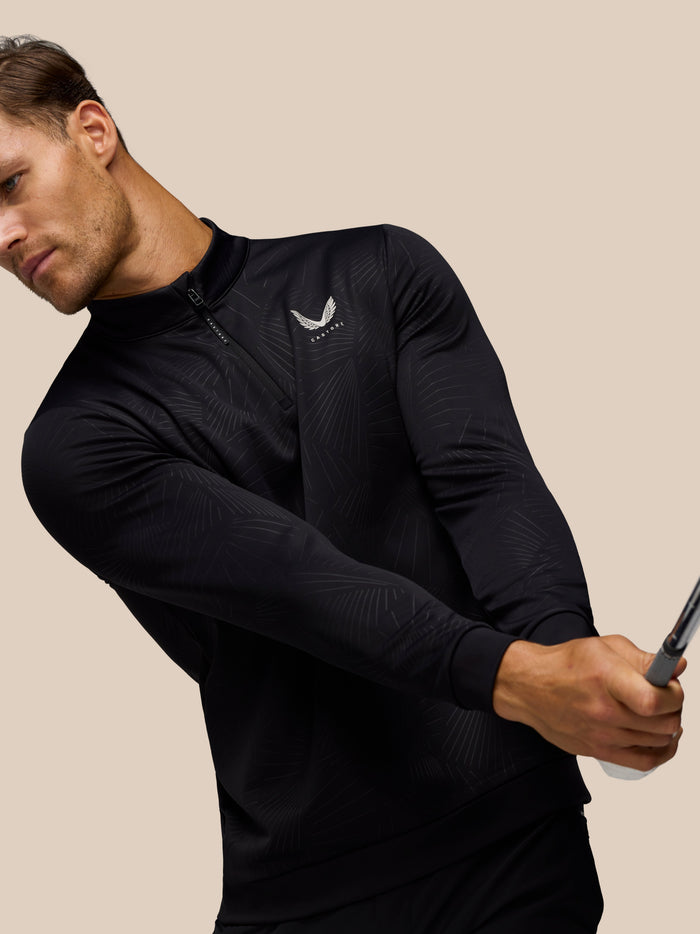 Side view of a man in black golf club classic quarter-zip top showing the zip and subtle embossed pattern.