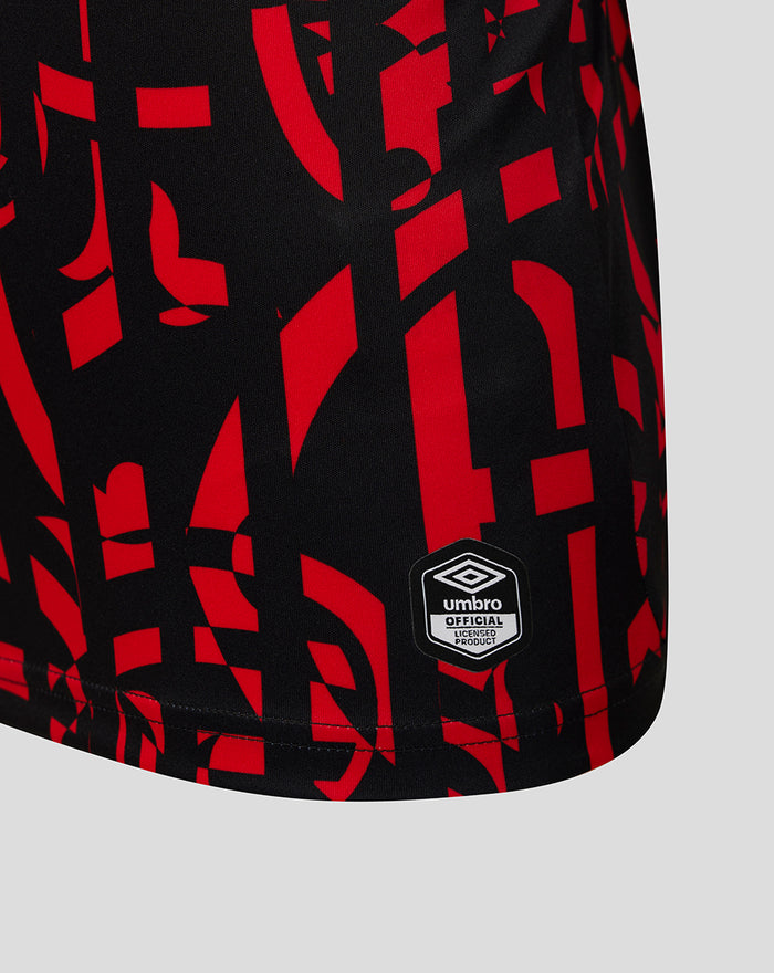 Hem area of Rangers junior shirt with Umbro official licensed product badge on black red abstract pattern
