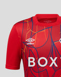 Front close-up of red Rangers FC junior away goalkeeper shirt with bold abstract graphics and large BOX lettering.