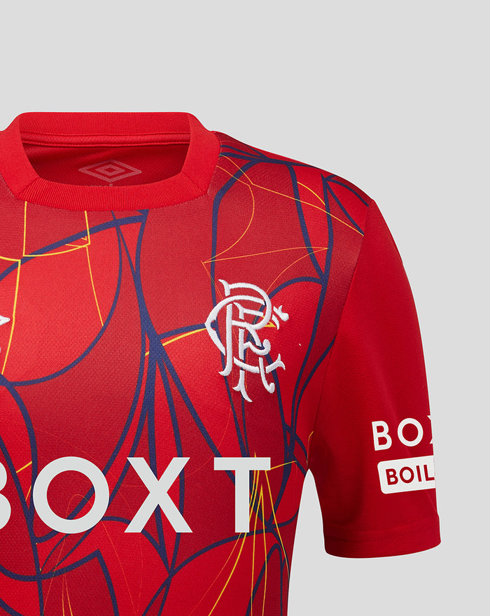 Shoulder and chest of red Rangers FC junior away goalkeeper shirt featuring crest and vibrant abstract pattern.