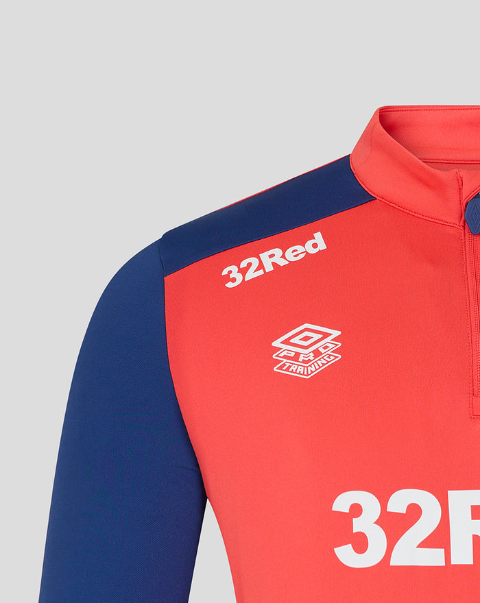 Close up of the Rangers FC training top showing the 32Red sponsor and Umbro Training logo on cayenne red chest with navy sleeves.