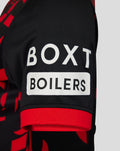 Close-up of sleeve on Rangers womens 2026/27 third shirt showing black fabric with red geometric pattern and a white sponsor patch