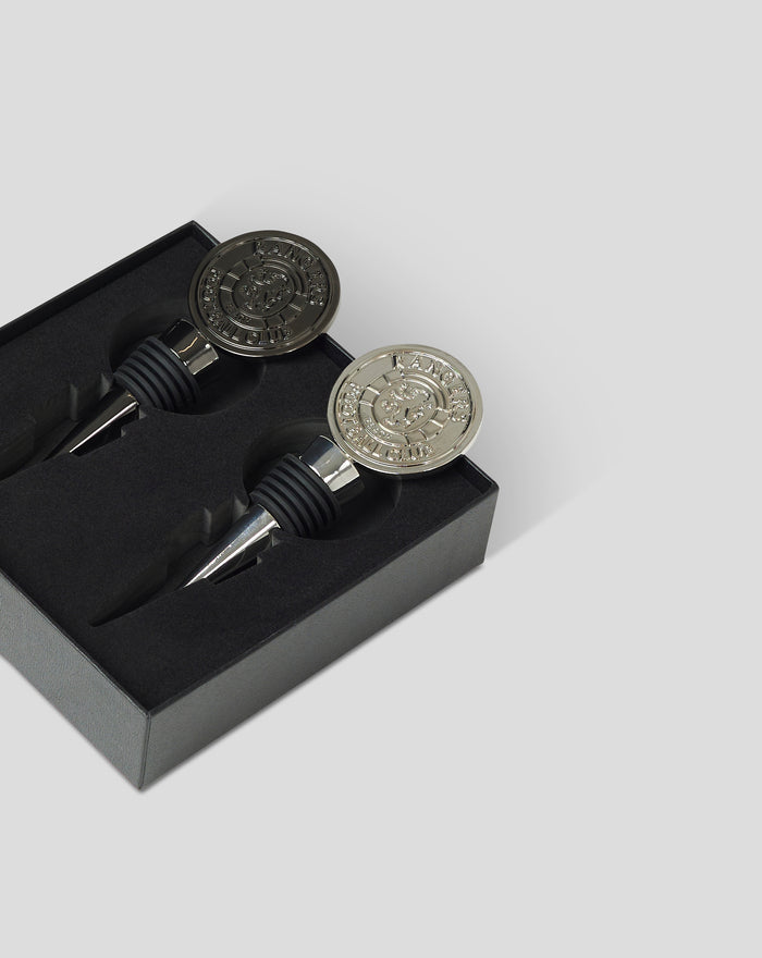 Gift set of two bottle stoppers, one dark and one silver, in a black display box.
