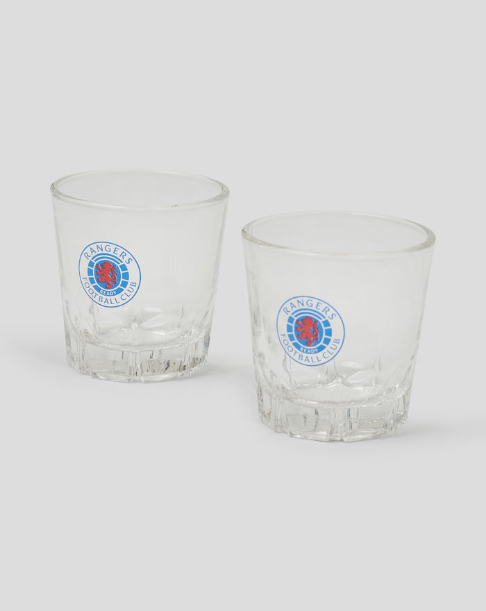 Two clear shot glasses with Rangers Football Club logos on each against a plain background