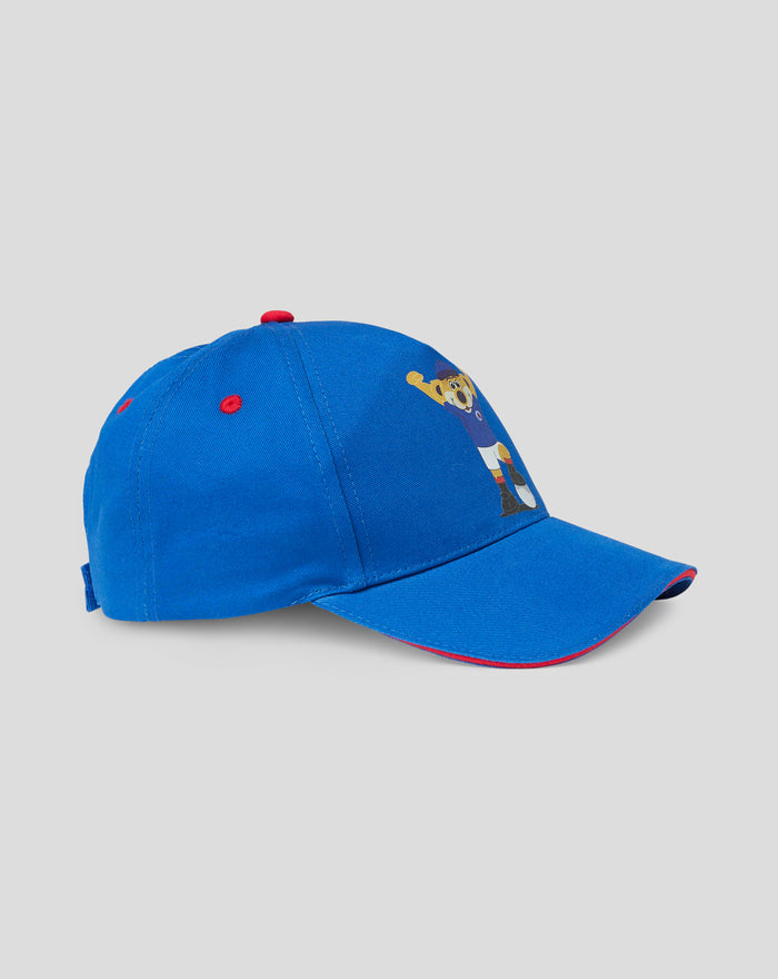 Blue BROXI cap side view with a red top button and partial bear graphic on the crown