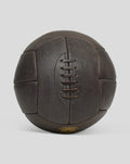 Close up side view of a dark brown deluxe leather football with lace detailing.