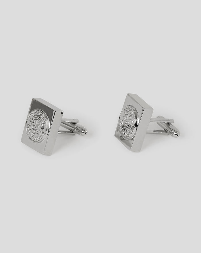 Pair of polished silver cufflinks with square faces and embossed crest detail