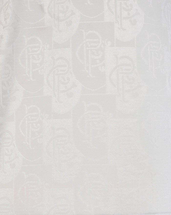 Close-up of white Rangers away shirt fabric showing a subtle repeating pattern and a small blue and white striped patch near the hem