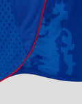 Close up of a blue unisex retro 2002-03 home shirt showing textured panels abstract camo pattern and red piping along the seam.
