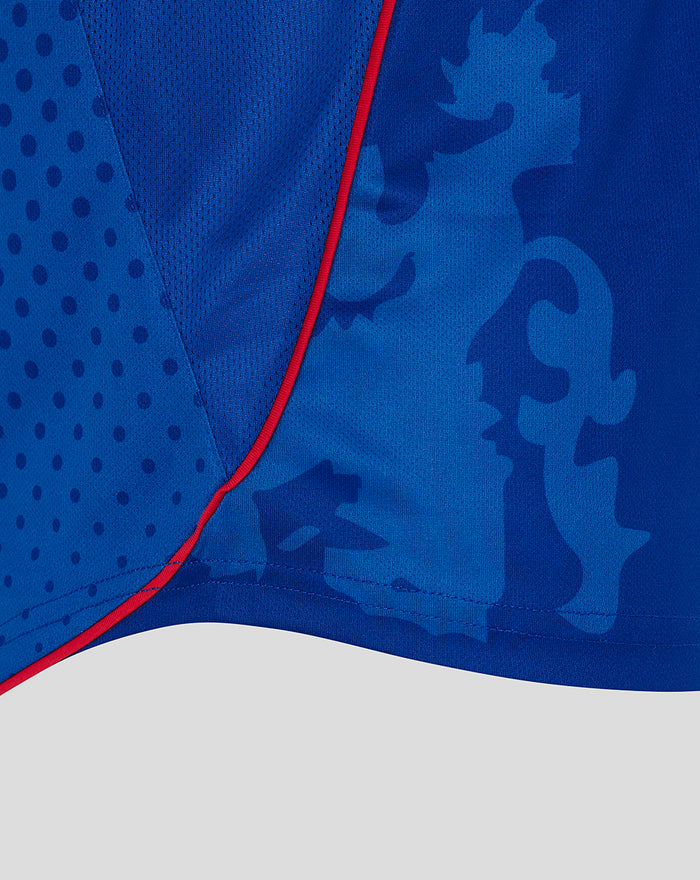 Close up of a blue unisex retro 2002-03 home shirt showing textured panels abstract camo pattern and red piping along the seam.