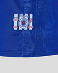 Blue retro home shirt fabric with a white striped patch badge featuring a red crest.