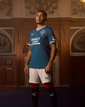 Male model wearing blue JUNIOR IBROX 125 Heritage Shirt with Rangers crest and Unibet sponsor.