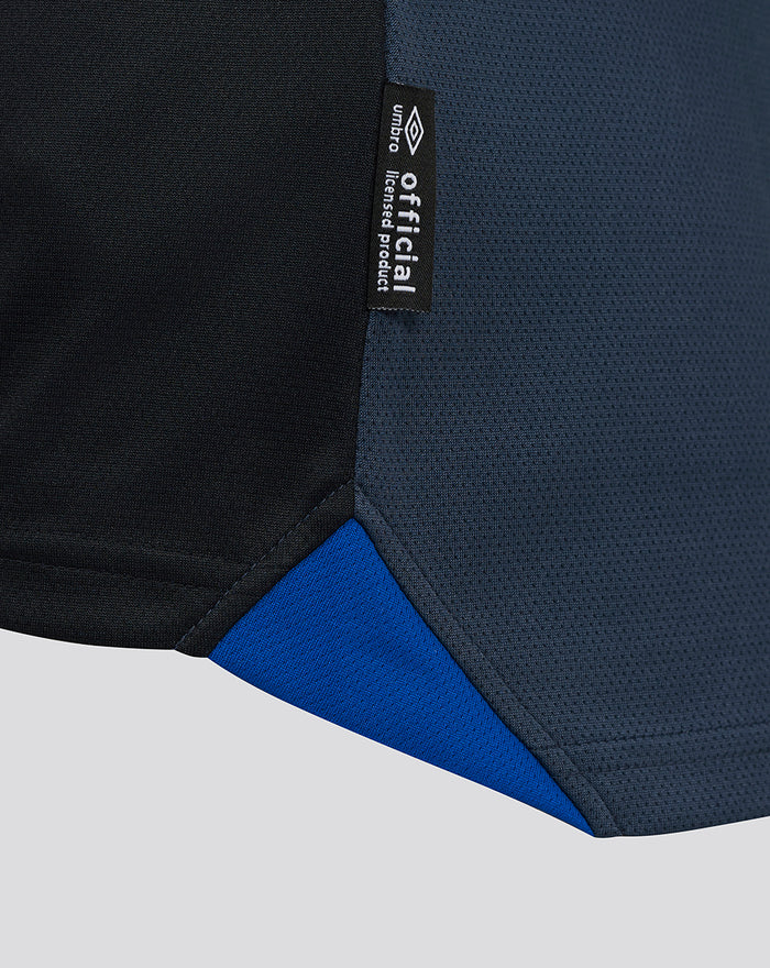 Close up of black official product tag attached to navy fabric of the Rangers third shirt.