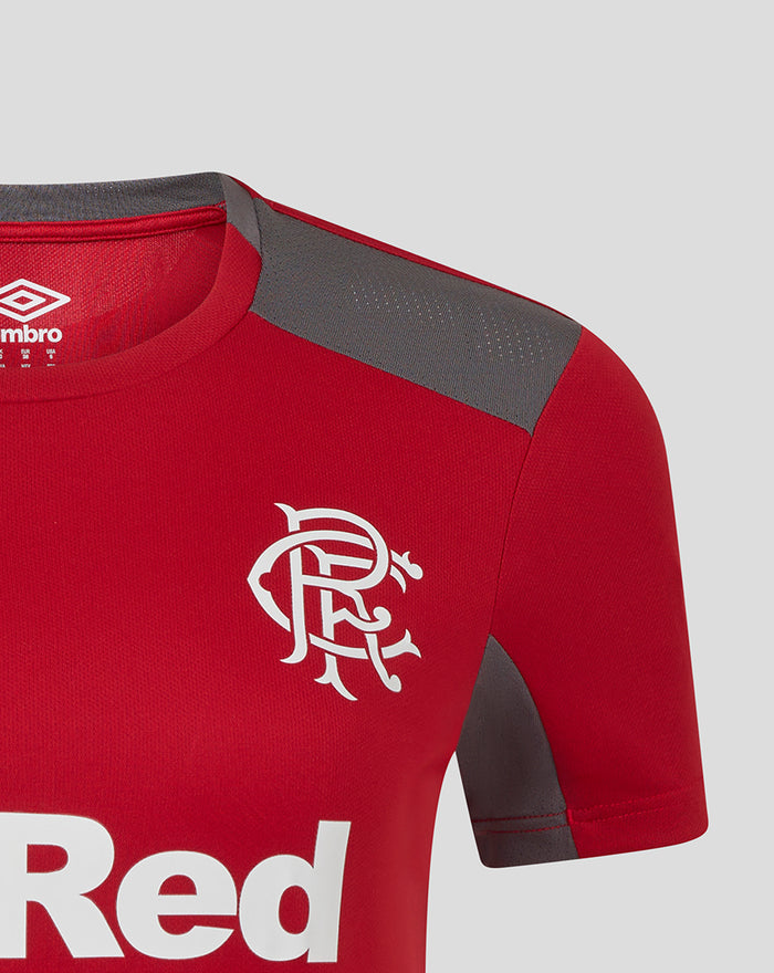 Close up of red women's training top shoulder with grey panel and team crest on chest