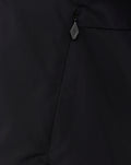 Zipper detail on a black hooded training jacket with a small diamond shaped zipper pull.