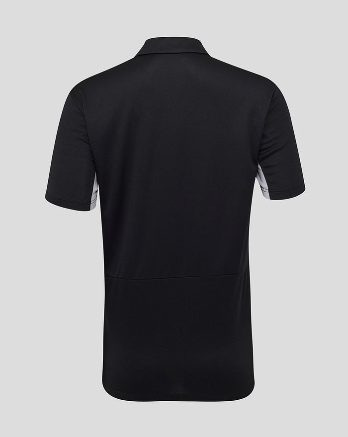 Back view of black womens poly polo showing short sleeves, a simple collar, and a curved hem