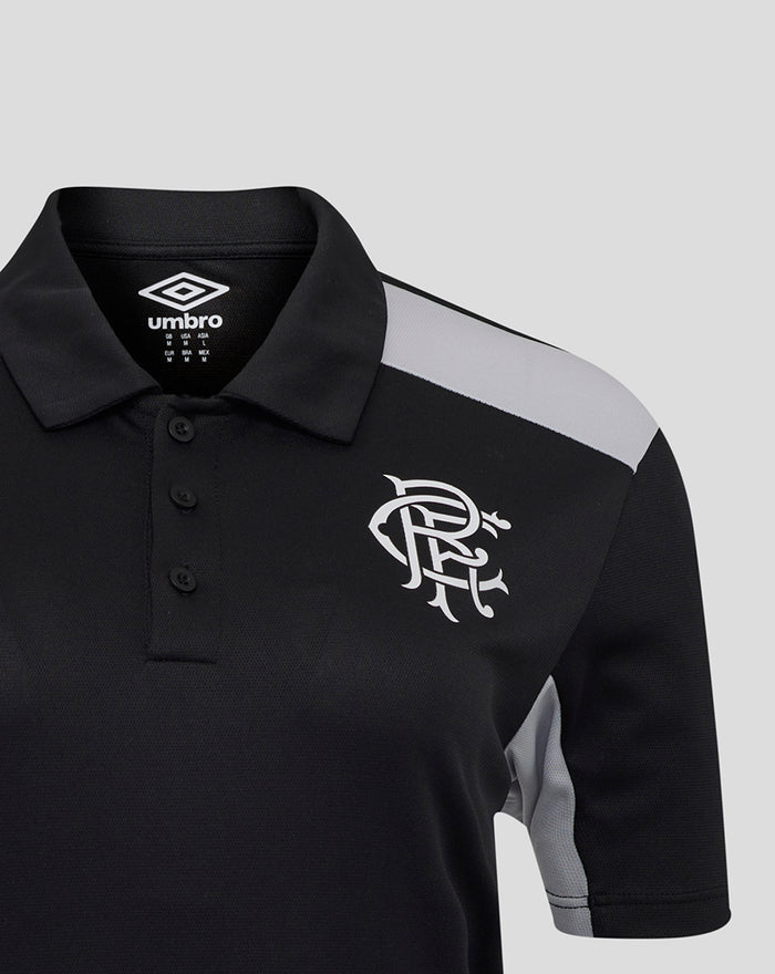 Close up of black polo with grey shoulder panel and white club crest on chest