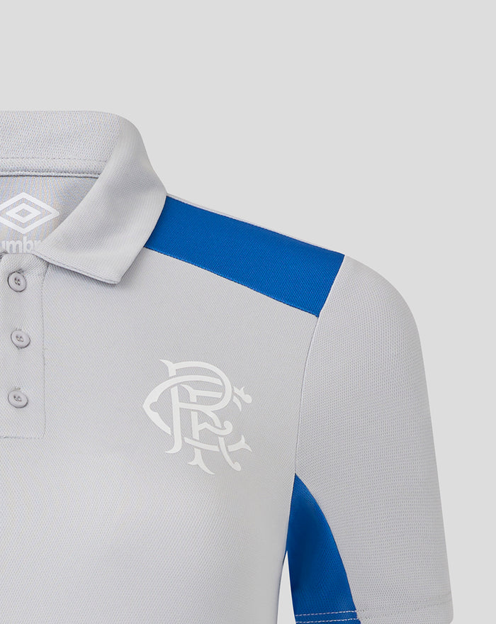 Shoulder and chest area of a light gray polo showing a blue shoulder stripe and the Umbro club crest on the left chest