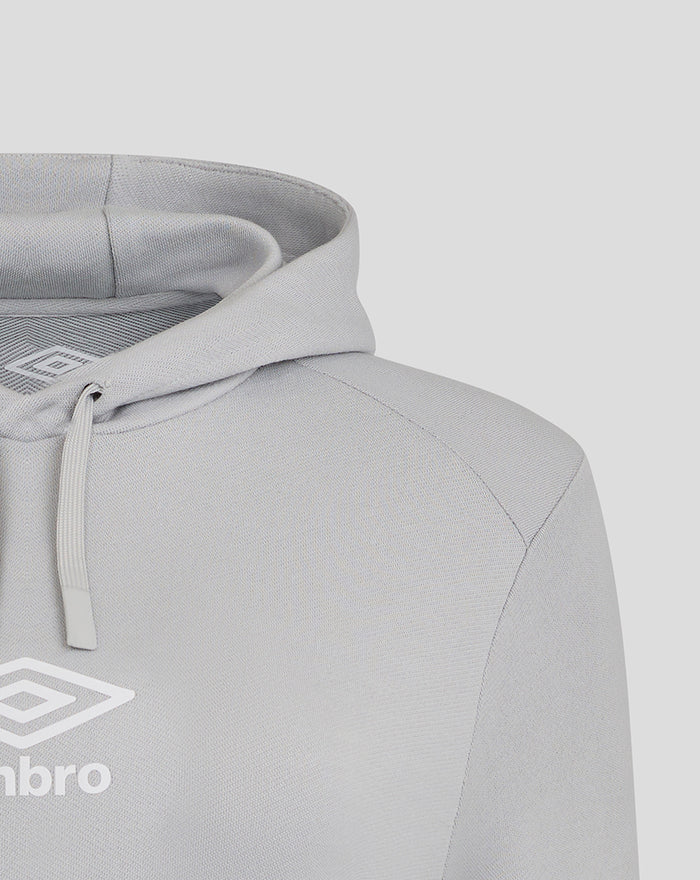 Detail of shoulder seam and hood on a light gray hoodie with visible Umbro logo near chest.