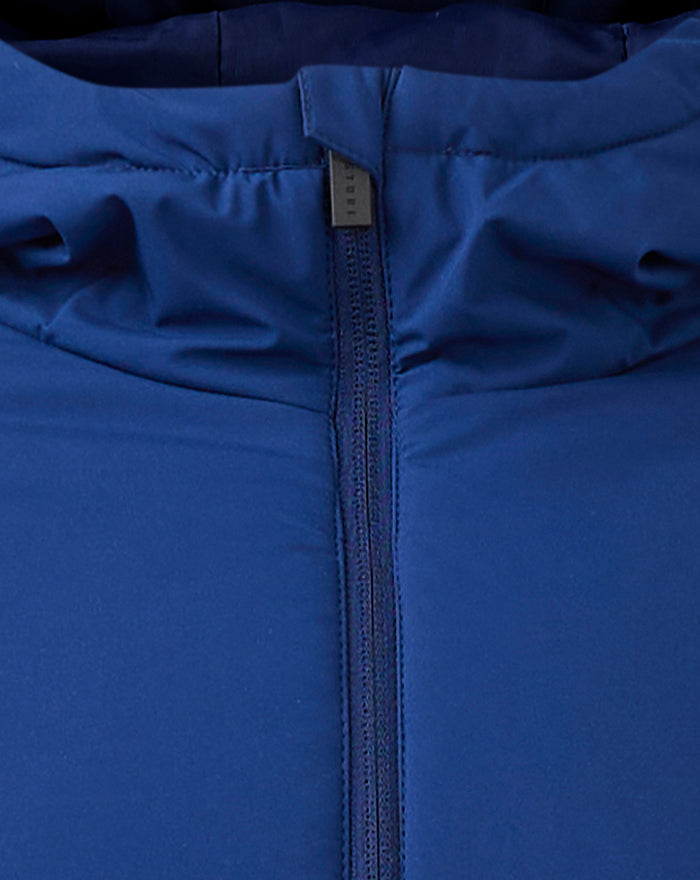 Close up of the blue Pro Players Bench jacket zipper with a small tag and Castore logo on the chest